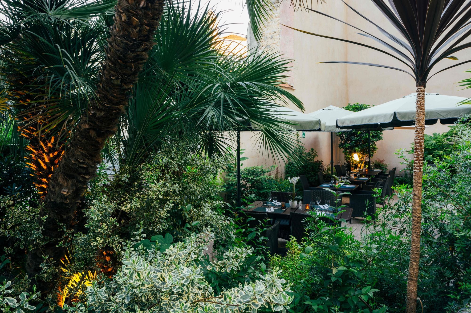 Espace de restauration en plein air avec une végétation luxuriante à Oceania Hotels