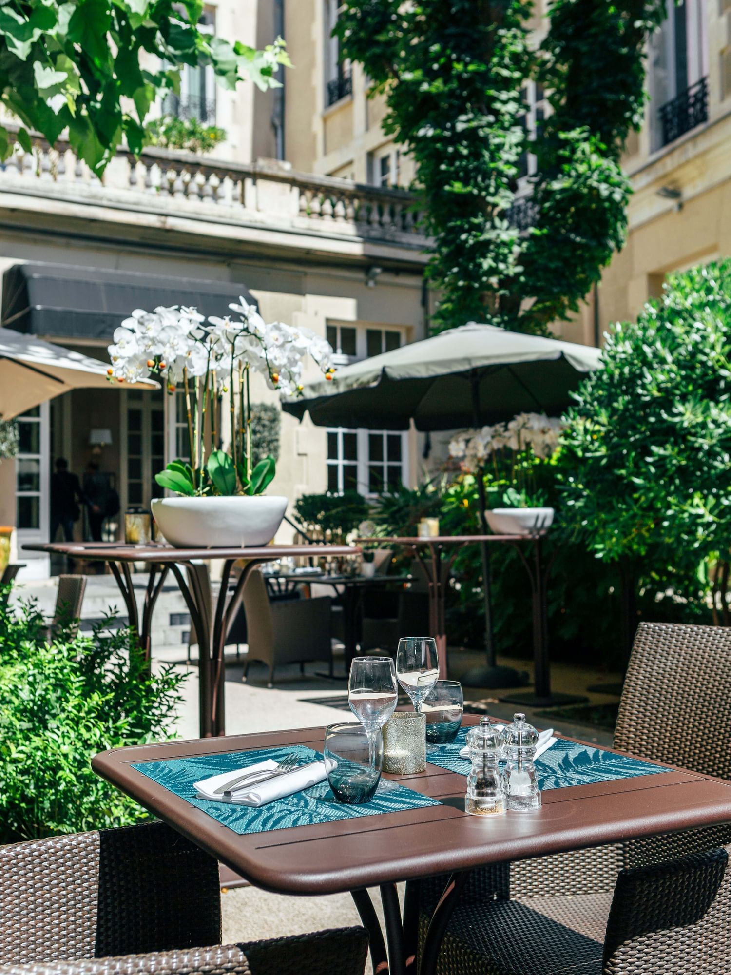 Espace de restauration en plein air avec une végétation luxuriante à Oceania Hotels