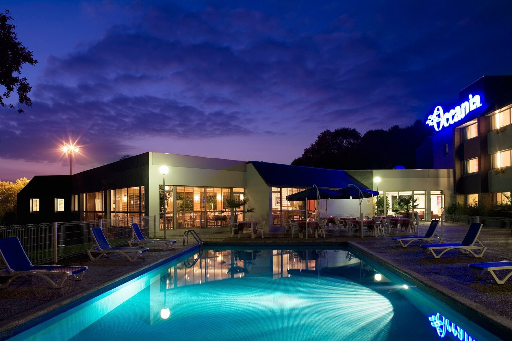 Chaises longues près de la piscine extérieure aux Oceania Hotels