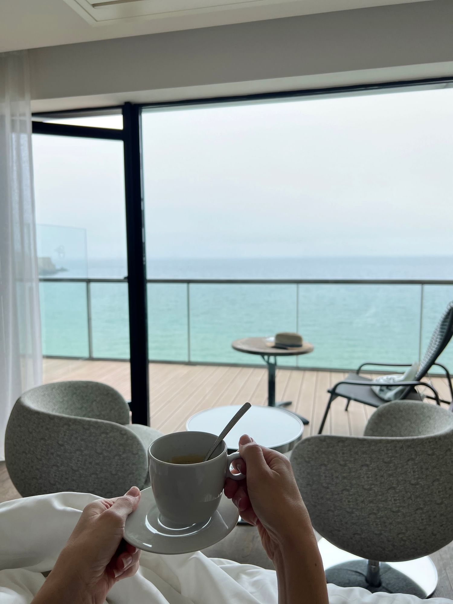 Dame prenant un café dans une chambre avec vue sur la mer, Oceania Hotels