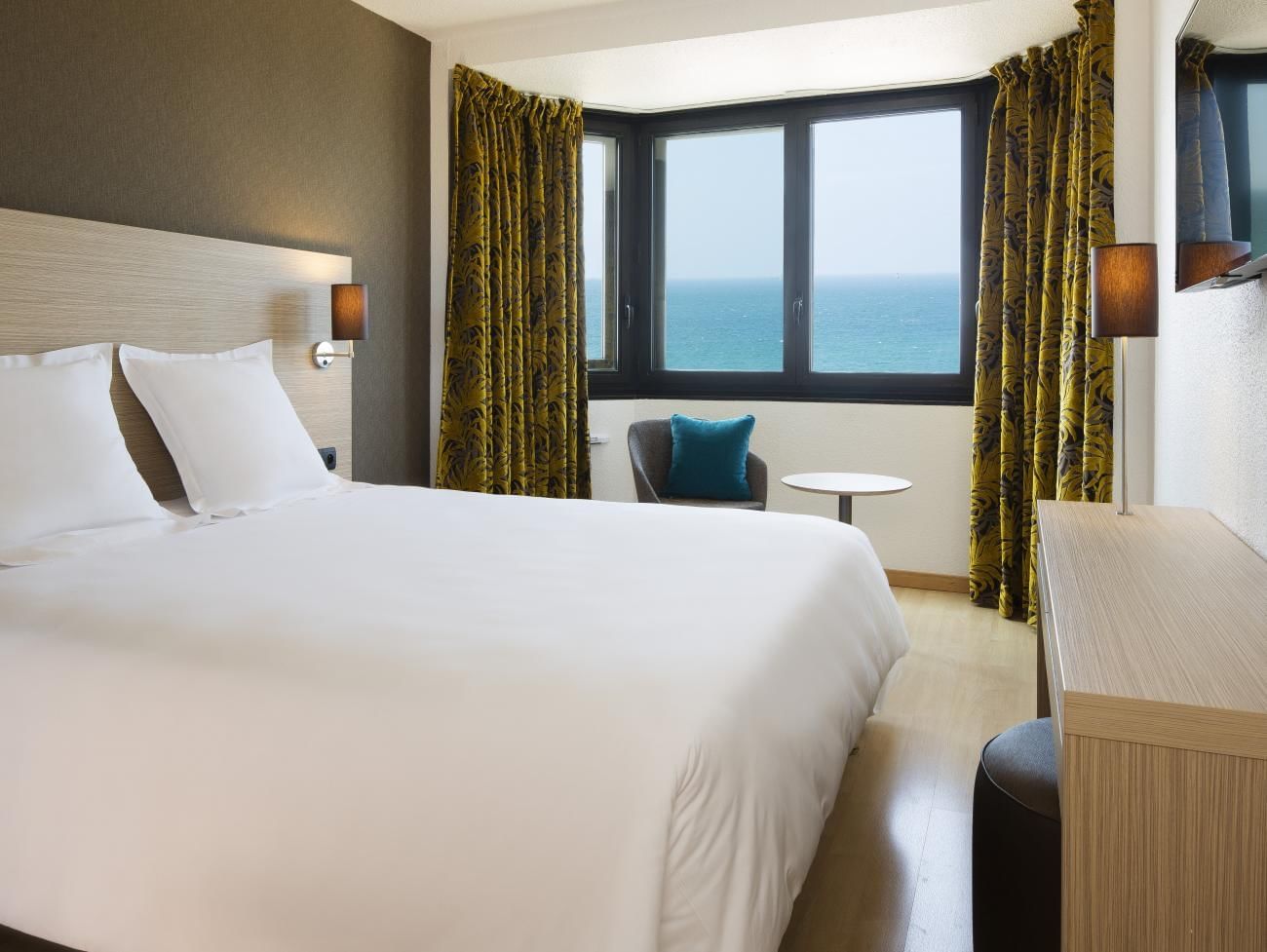 Lit et bureau dans les chambres familiales aux Oceania Hotels