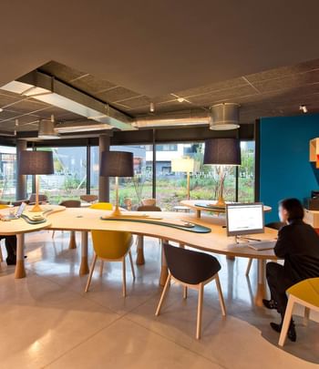 Coin Business aménagé avec une grande table et des chaises au Nomad Hotels Paris Roissy